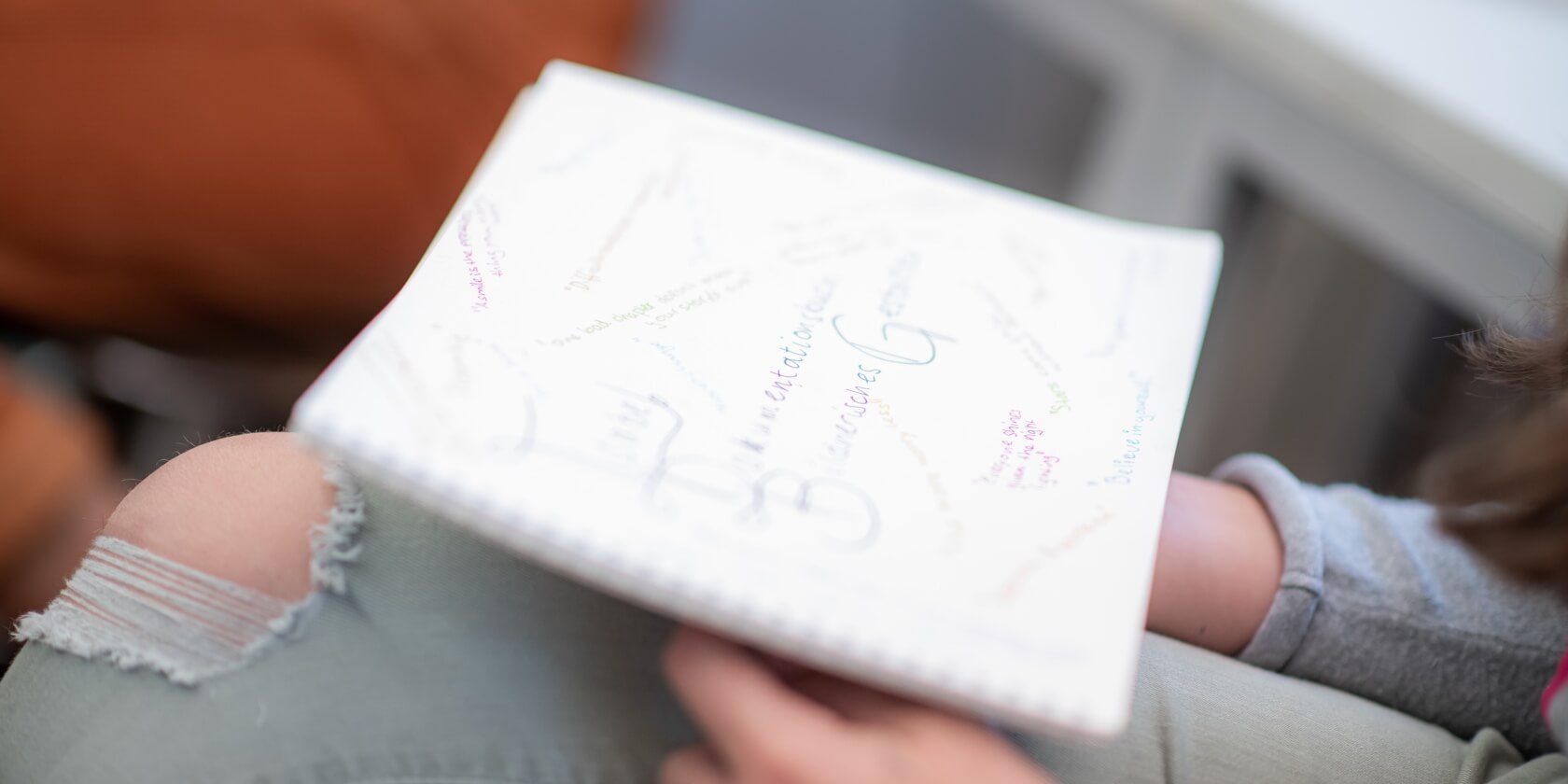 Schulheft auf dem Schoss eines Schülers