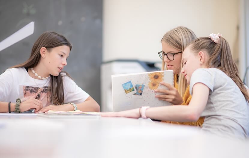 Drei Schülerinnen sind am diskutieren im Unterricht